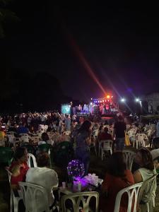 a crowd of people sitting in chairs at a party at night at Akaiah in Santo Domingo