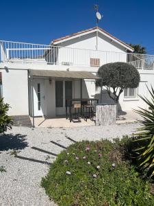 una casa bianca con un tavolo davanti di Joli appartement privé jardin à 10min des plages ad Agde