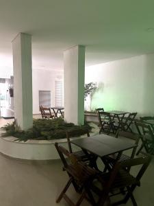 un grupo de mesas y sillas en un edificio en Bertioga, clube completo com piscina aquecida, en Bertioga