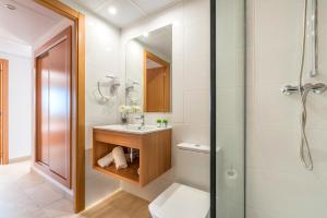 a bathroom with a toilet and a sink and a shower at Apartaments Condado by Marsol in Lloret de Mar