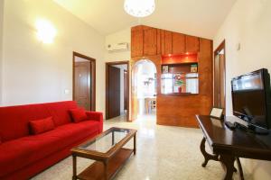 a living room with a red couch and a table at Residence Speedy Lovely Suites - 9 Appartamenti Fino a 52 Ospiti - Fiumicino Airport in Fiumicino +144 photos