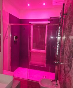 une salle de bain rose avec une douche et un lavabo dans l'établissement Blu Sky Apartment, à Santa Maria delle Mole