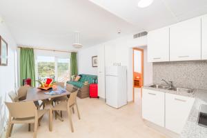 a kitchen and living room with a table and chairs at Apartaments Condado by Marsol in Lloret de Mar