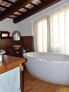 a large white tub in a bathroom with a window at Can Japet in Santa Llogaia del Terri