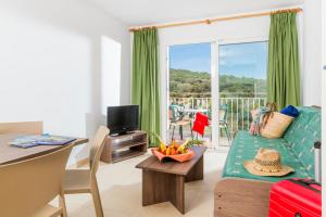 a living room with a couch and a table at Apartaments Condado by Marsol in Lloret de Mar