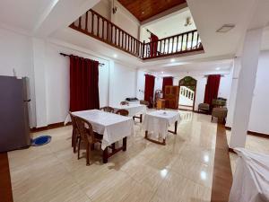 a dining room with tables and chairs and a staircase at Pearl Rest in Mannar