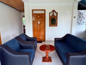 a living room with two blue couches and a table at Pearl Rest in Mannar