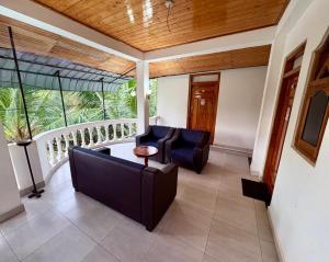 a porch with a couch and chairs on a balcony at Pearl Rest in Mannar