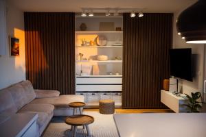 a living room with a couch and two stools at Sea Whisper apartment Zadar in Zadar