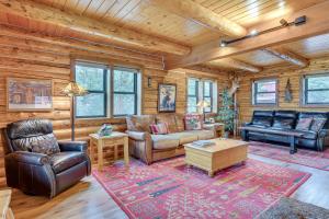 a living room with leather furniture in a log cabin at 18 Mi to Royal Gorge Peaceful Mtn Cabin with Porch! in Cotopaxi