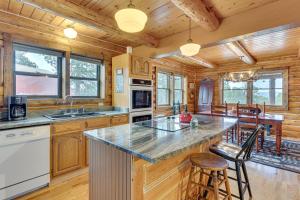 a kitchen with a large island in a log cabin at 18 Mi to Royal Gorge Peaceful Mtn Cabin with Porch! in Cotopaxi
