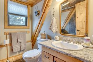 a bathroom with a sink and a toilet and a mirror at 18 Mi to Royal Gorge Peaceful Mtn Cabin with Porch! in Cotopaxi +18 photos
