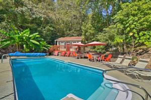 a swimming pool with chairs and a table and umbrellas at about 1 Mi to Dollywood Family Home with Pool and Hot Tub in Pigeon Forge