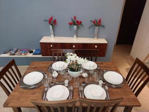 un tavolo in legno con sedie, piatti e fiori di Oceanview Pool Near Av 5th Beach 6 Guest Fast WiFi a Playa del Carmen