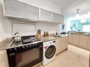 una cucina con fornelli e lavatrice di Oceanview Pool Near Av 5th Beach 6 Guest Fast WiFi a Playa del Carmen
