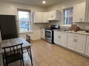 a kitchen with white cabinets and a table with chairs at Little France Unit 2 in Allentown
