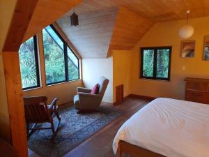 una camera da letto con un letto, una sedia e finestre di The Hub a Collingwood