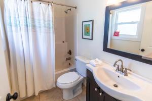 a bathroom with a toilet and a sink and a mirror at Beasley Beach House in Blue Mountain Beach +48 photos