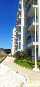 un edificio de apartamentos blanco en una playa con una acera en Apartamento 308 Coralina suites, en Santa Marta