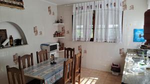 a kitchen with a table and chairs and a counter at Casa de Campo em Biritiba Mirim in Biritiba-Mirim