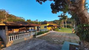 a house with a fence and a driveway at Casa de Campo em Biritiba Mirim in Biritiba-Mirim