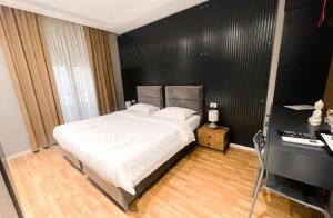 a bedroom with a large white bed and a desk at Tirana Escape Rooms in Tirana