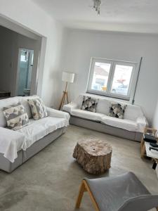 ein Wohnzimmer mit zwei Sofas und einem Couchtisch in der Unterkunft Sunshine Patio Getaway in Vila Nova de Milfontes