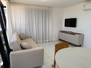 a living room with a white couch and a television at Edificio Neo Apto 401 in Maceió