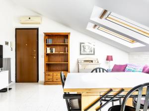 a room with a table and chairs and a book shelf at piccola gemma apartment in Grottaferrata