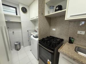 a small kitchen with a stove and a sink at Edificio Neo Apto 401 in Maceió