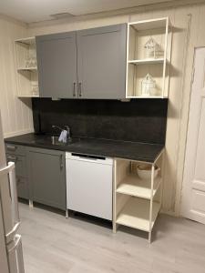 una cucina con mobili bianchi e un lavandino di Hus med 2 leiligheter a Kristiansand Altre 14 foto