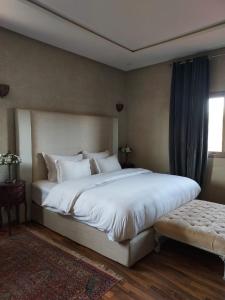 une chambre avec un grand lit blanc et une fenêtre dans l'établissement Villa Azuréa with pool 4 bedrooms and 2 living rooms, à Ourika 23 autres photos