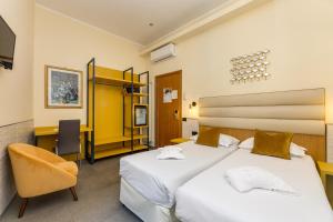 a hotel room with two beds and a chair at Seven in Rome