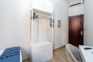 a room with a white closet and a desk at Portafortuna GUESTHOUSE - close to COLOSSEUM in Rome