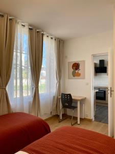 a bedroom with a bed and a desk and a window at L'Espérance vue sur la Loire et la vigne 2 in Pouilly-sur-Loire