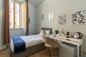 a bedroom with a bed and a desk with a computer at Portafortuna GUESTHOUSE - close to COLOSSEUM in Rome +84 photos