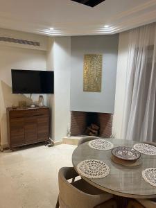 a living room with a table and chairs and a television at Appartement le vizir center in Dar Caïd Layadi +31 photos