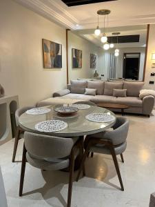 a living room with a table and chairs and a couch at Appartement le vizir center in Dar Caïd Layadi
