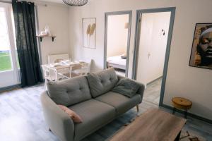 a living room with a couch and a table at La parenthèse du sud Parking calme et confort in Valence