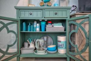 a green cabinet with dishes and other items on it at Pacific Plaza #505 - Coastal Gem - StudioD-Q in Oceano