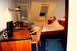 Habitación de hotel con cama y escritorio con ordenador en Hotel Restaurant Bären, en Freudenstadt