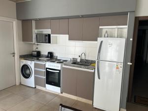 een keuken met een koelkast en een wasmachine bij BELGRANO SUITES in Salta