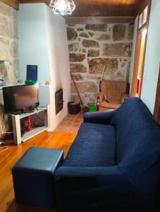 a blue couch in a living room with a stone wall at Serra da Estrela - Casa Castro in Gouveia