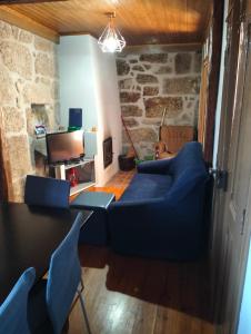 a living room with a blue couch and a table at Serra da Estrela - Casa Castro in Gouveia