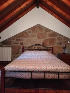 a bed in a room with a stone wall at Serra da Estrela - Casa Castro in Gouveia +31 photos