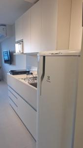 a white kitchen with a refrigerator and a stove at Skylux 3003 in Rio de Janeiro