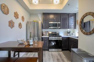 a kitchen with black cabinets and a table with wine glasses on it at Pacific Plaza #308 - Lazy Dune - 1BdrmUp-K-QSofa in Oceano