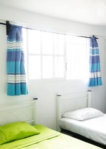 a bedroom with a bed and a window at Hostal Azul y Blanco in Santa Cruz Huatulco