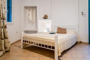 Cama blanca en habitación con ventana en Seaside Apartments en Adamas