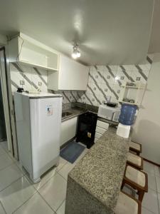 a small kitchen with a refrigerator and a counter at Nannai Residence - Muro Alto - Porto de Galinhas in Porto De Galinhas